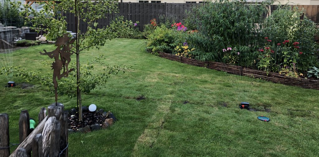 Sicht in den Garten mit laufenden Rasensprengern